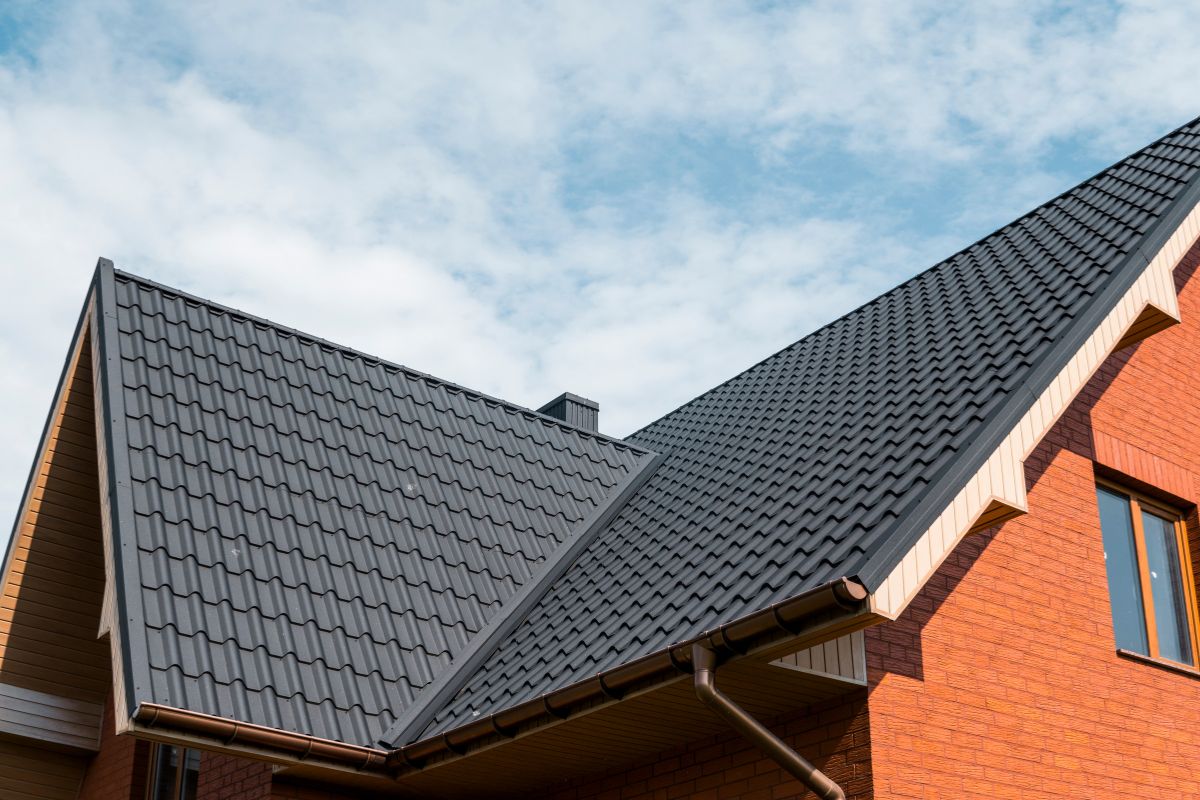  A house featuring a metal roof and a single window, showcasing a modern architectural design.